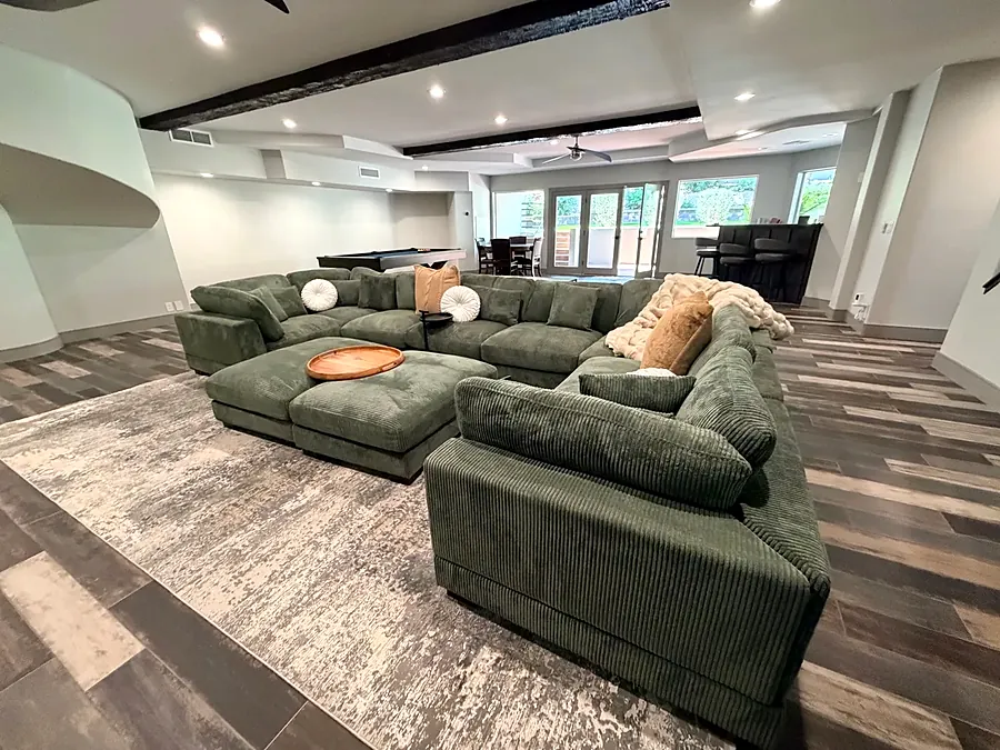 Lounge with a large green sectional sofa and cushions
