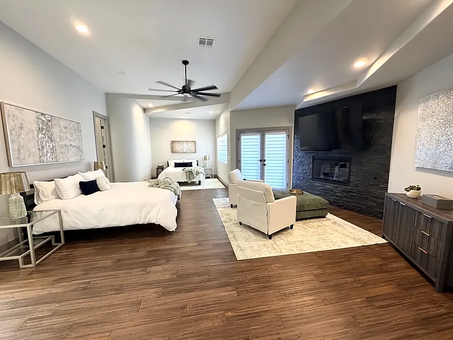 Master bedroom at the house with a king bed, sofa and fireplace wall